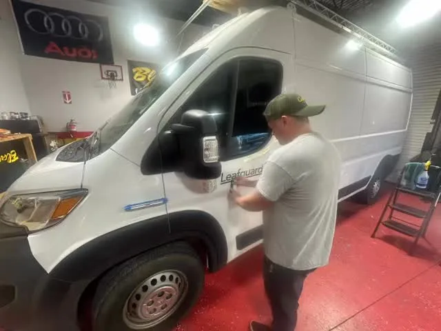 Installer tinting a Sprinter van in the Powhatan bay